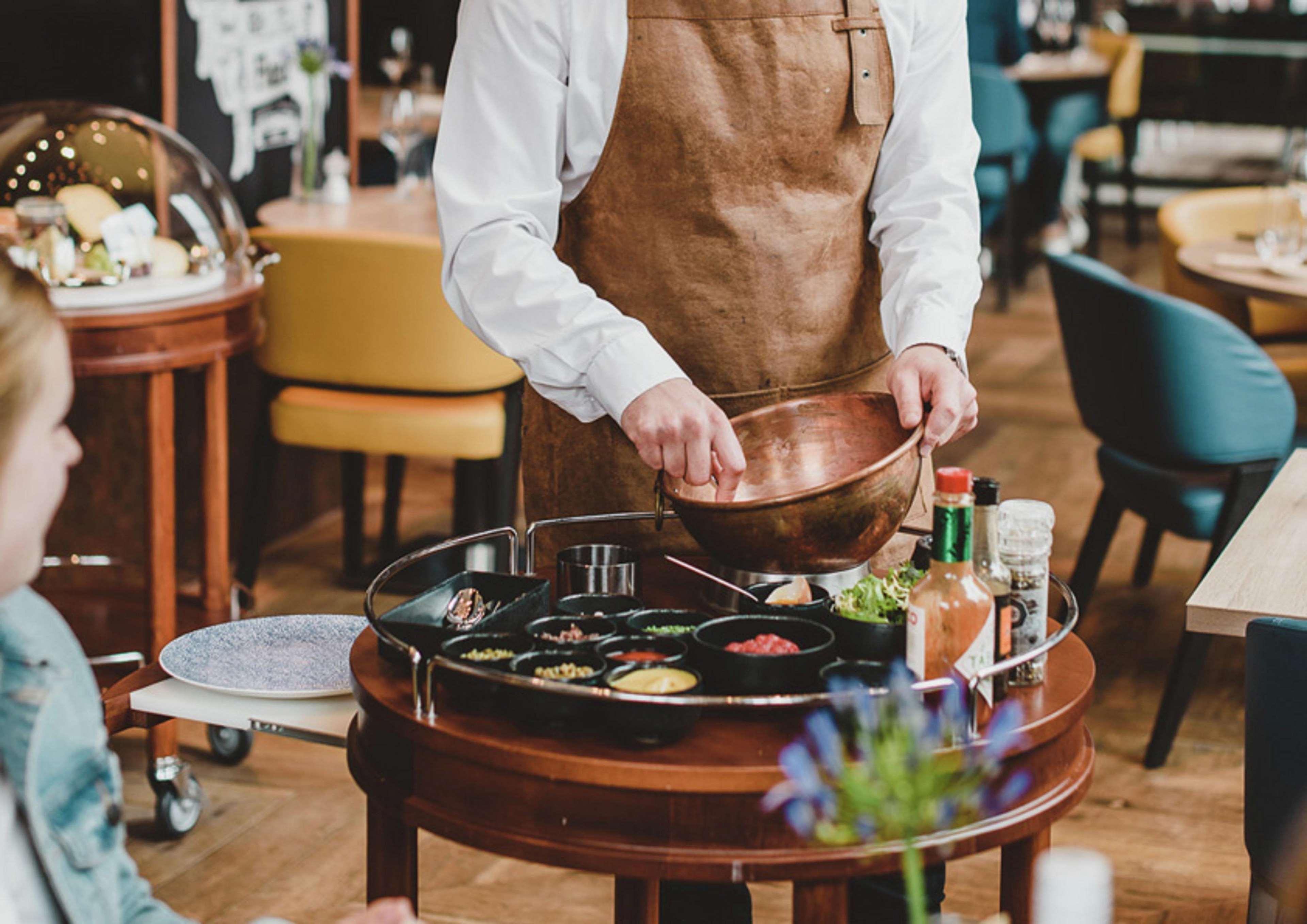 Hilton The Hague Hotel Kültér fotó A server prepares a dish at a restaurant